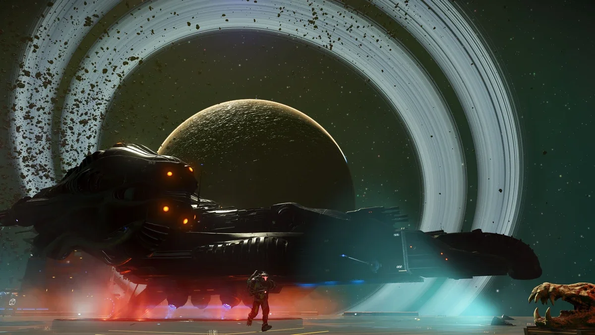 A dark biomechanical starship with glowing orange lights hovers over a landing pad in front of a ringed planet, a pilot in a spacesuit standing below